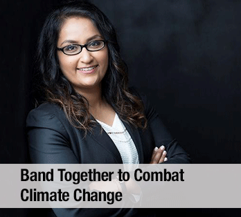 A woman wearing a suit and glasses in front of a dark background - Band together to combat climate change