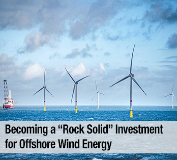 Five wind turbines in a body of water with a boat in the background - Becoming a rock solid investment for offshore wind energy
