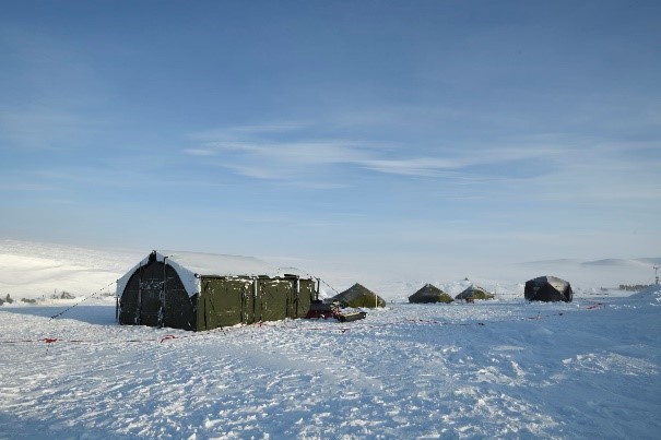 A small cluster of deployed military camps is shown in a snowy Arctic landscape.