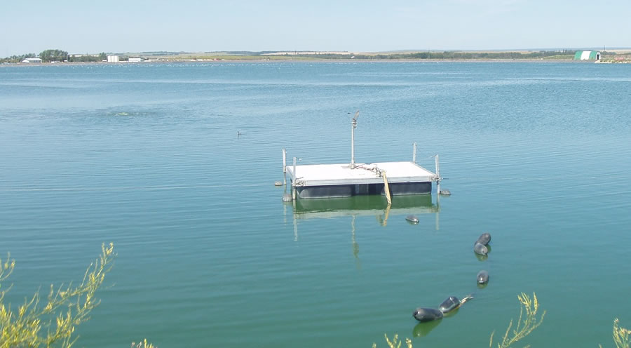 Sewage lagoon with floating pump platform in Clairmont, Alberta
