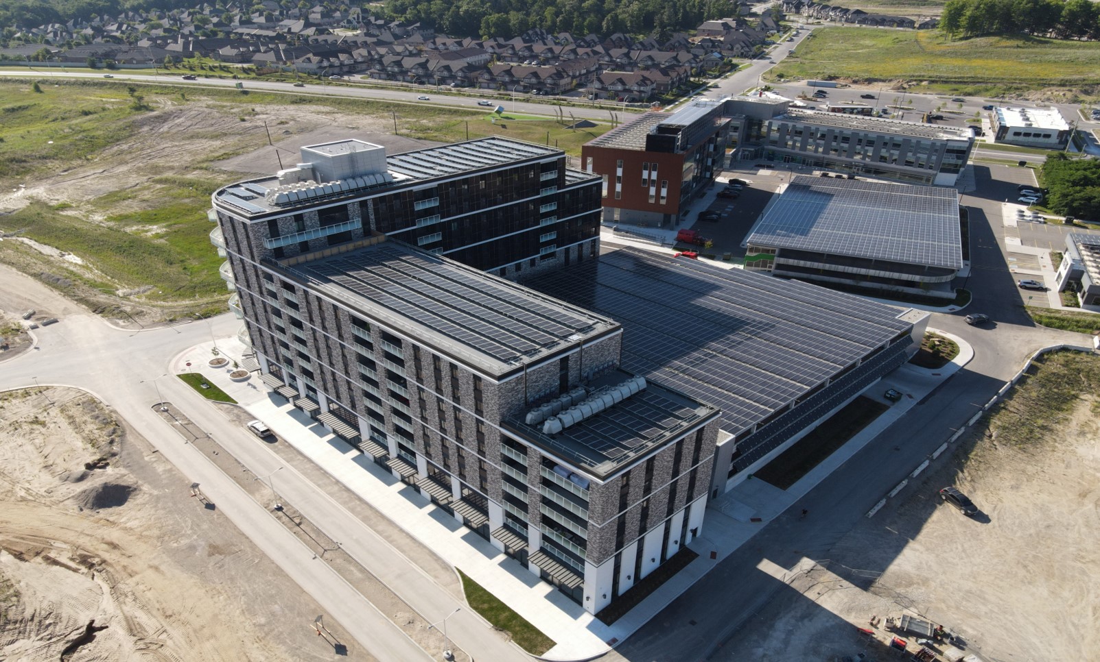 An aerial photograph of the Legacy Square Plaza and Helio Commercial Retail Services buildings with solar PV installed on the roof.
