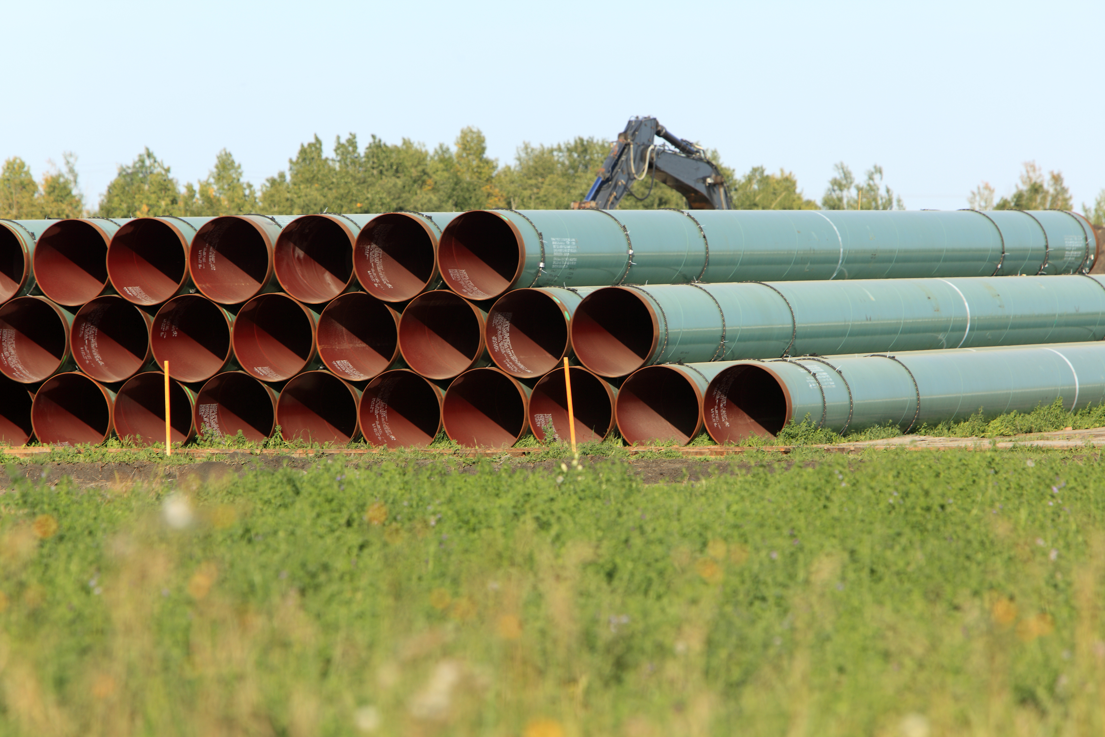 Stack of pipe sections ready for laying pipeline across prairie land