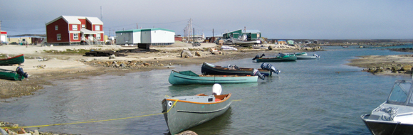 Photograph of personal fishing boats tied up along the shore of Clyde River