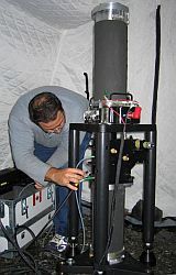 Technician taking gravity measurements on the ground in a tent