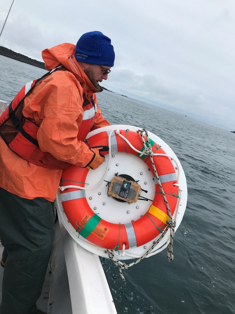 Researcher Richard Cheel is preparing to deploy the drifter instrumentation buoy overboard the vessel
